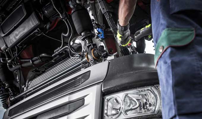 Mechanic working on truck engine — mobile workshop